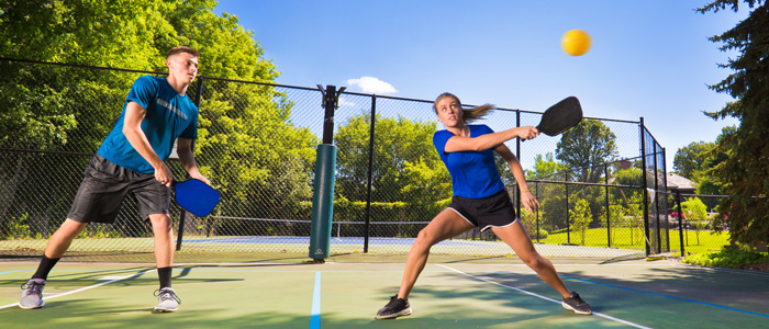 A man and a woman playing pickleball